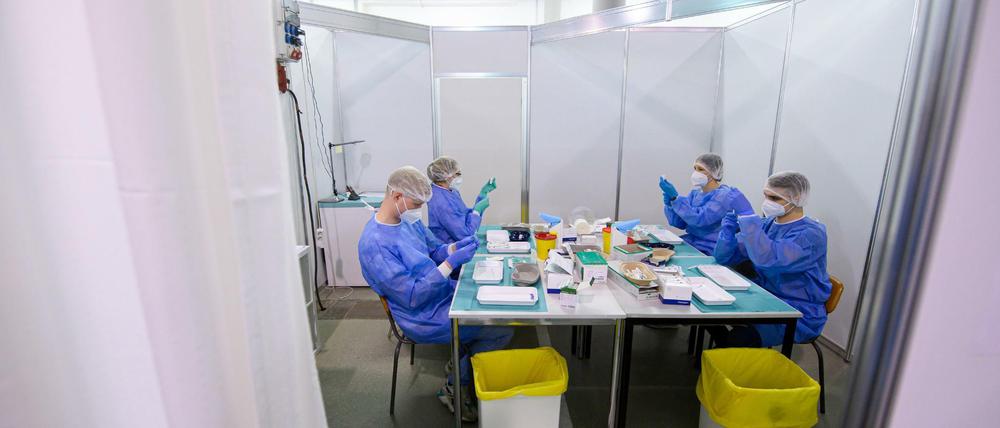 Mitarbeiter:innen im Impfzentrum in der Messe Dresden bereiten Spritzen für die Impfung gegen Corona vor.