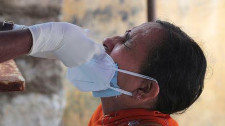 Ein medizinischer Mitarbeiter entnimmt einer Frau einen Nasenabstrich für einen Corona-Test. Indien ist das weltweit am zweitstärksten von der Pandemie betroffene Land. 