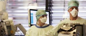 Zwei Mediziner untersuchen einen Intensivpatienten in der Uniklinik Aachen.