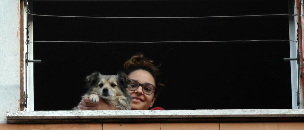 In Rom schaut eine junge Frau aus dem Fenster, während einer der vielen Flashmobs gegen Einsamkeit, die durch die Isolierung angesichts des Coronavirus-Ausbruchs verursacht wurden.