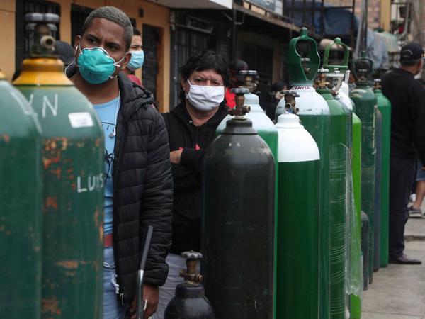 In Peru stehen Menschen stehen Schlange, um ihre leeren Sauerstoffflaschen wieder aufzufüllen.