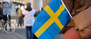 Eine Teilnehmerin einer Coronaleugner-Demonstration mit einer schwedischen Flagge.