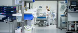 Zwei medizinische Mitarbeiter beobachten auf der Intensivstation eines Schweizer Klinikums einen Corona-Patienten.