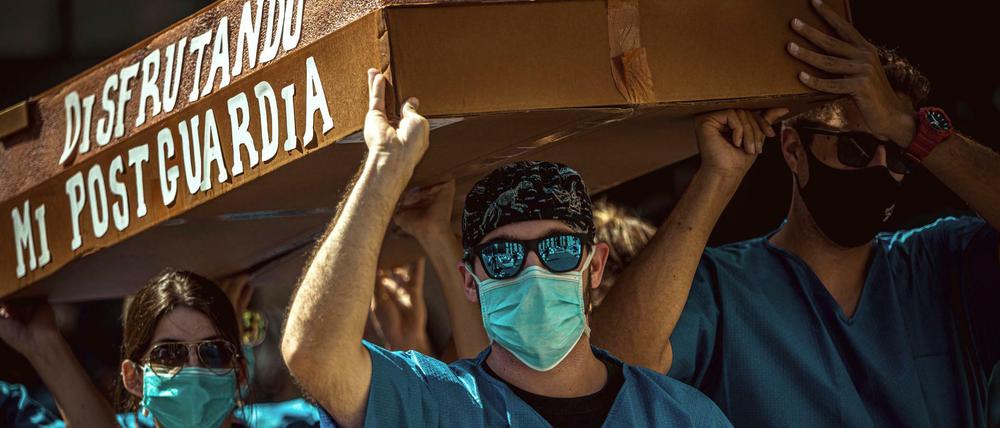 "Ich genieße die Zeit nach meinem Bereitschaftsdienst", steht symbolisch an einem Sarg geschrieben, der von Assistenzärzten bei einem Protest für bessere Arbeitsbedingungen in Barcelona getragen wird.