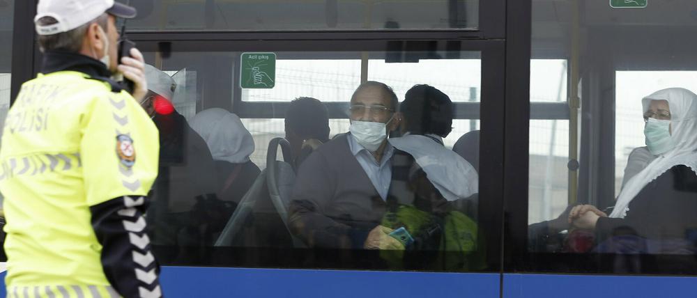 Pilger sitzen am 15.03.2020 in einem Bus, der sie vom Flughafen zu Studentenwohnheimen außerhalb Ankaras gebracht hat, wo sie unter Quarantäne gestellt werden sollen.
