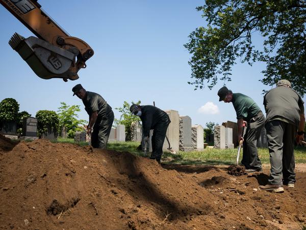 So viele Tote, so viele Gräber. Ein Friedhof im Bundesstaat New York. : Mitarbeiter des Friedhofs "Calvary Cemetery" arbeiten während der Corona-Pandemie an einem Grab. Foto: Michael Nagle/XinHua/dpa +++ dpa-Bildfunk +++