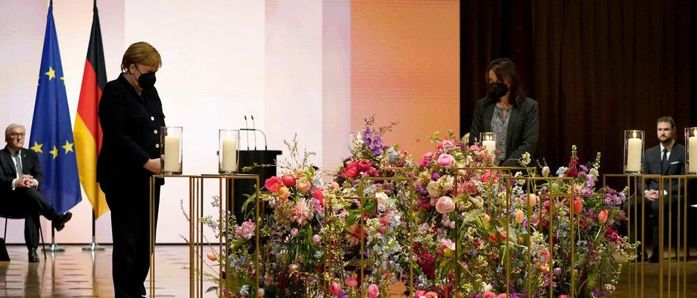 Kerzen für die Toten. Bundespräsident Frank-Walter Steinmeier (l-r), Bundeskanzlerin Angela Merkel (CDU) und Angehörige von Opfern der Corona-Pandemie bei der nationalen Gedenkstunde für die Verstorbenen in der Corona-Pandemie im Berliner Konzerthaus