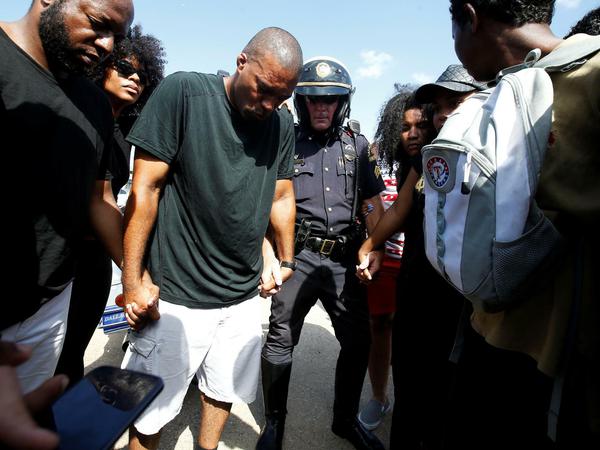 Ein Polizist in Dallas schließt sich den Gebeten von Mitgliedern der Black-Lives-Matter-Bewegung an. 