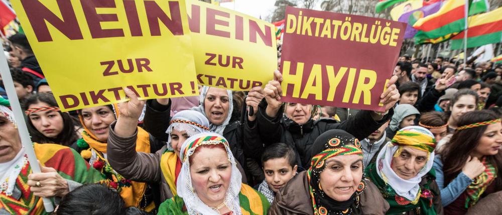 Kurdische Demonstranten gehen während einer Kundgebung zum kurdischen Frühjahrsfest Newroz am Dienstag in Frankfurt am Main mit Plakaten mit der Aufschrift "Nein zur Diktatur" durch die Innenstadt.