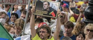 Ein Mann hält bei einer Demonstration in Chabarowsk ein Plakat mit einem Porträt von Alexej Nawalny.