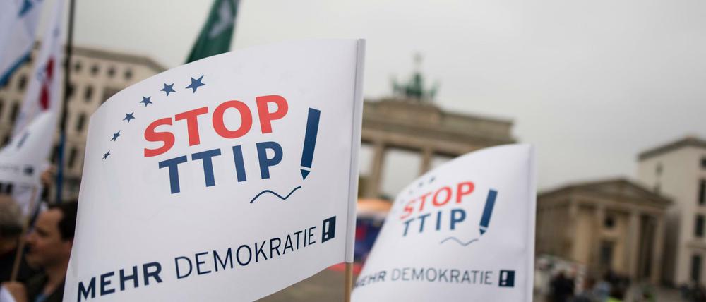 Verschiedene Aktionsbündnisse stehen am 07.10.2015 mit Fahnen mit der Auschrift "Stop TTIP" vor dem Brandenburger Tor in Berlin, um für eine geplante Großdemonstration am 10.10.2015 gegen die Handelsabkommen TTIP und CETA zu werben. 