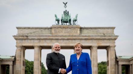 Bundeskanzlerin Angela Merkel (CDU) und der indische Premierminister Narendra Modi reichen sich am Dienstag auf dem Pariser Platz vor dem Brandenburger Tor die Hand.