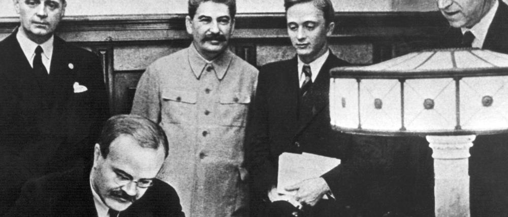 Die Außenminister des Deutschen Reiches, Joachim von Ribbentrop (l), und der sowjetische Außenminister Wjatscheslaw Molotow (vorn) unterzeichnen in Moskau den deutsch-russischen Nichtangriffspakt. 