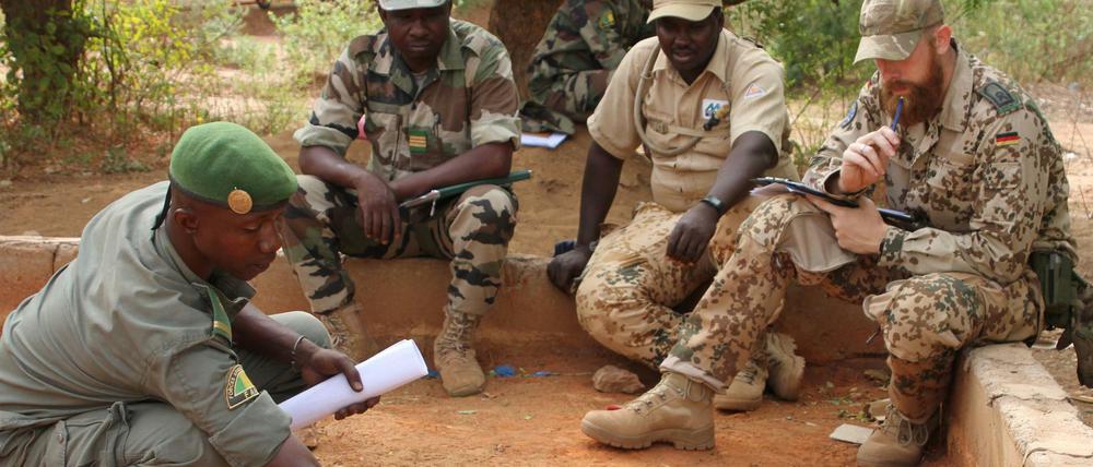 Malische Soldaten besprechen sich mit einem Ausbilder der Bundeswehr.