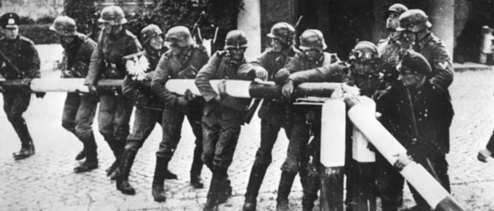 Soldaten der Wehrmacht reißen am 1. September 1939 einen Schlagbaum an der Grenze zu Polen nieder. 