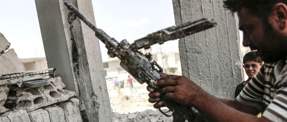 Ein Mann in Kobane im Norden Syriens trägt eine vom IS erbeutete Waffe.