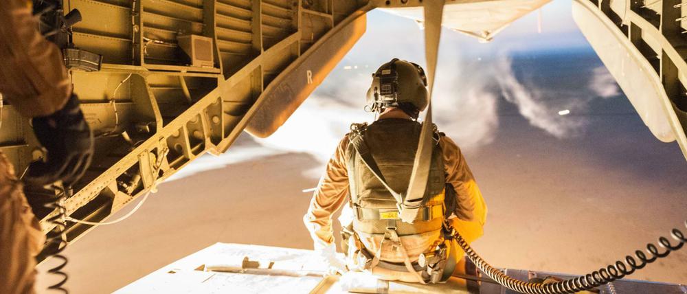 Ein Soldat der Bundeswehr sitzt bei Mazar-i-Sharif der offenen Ladefläche eines Helikopters. 