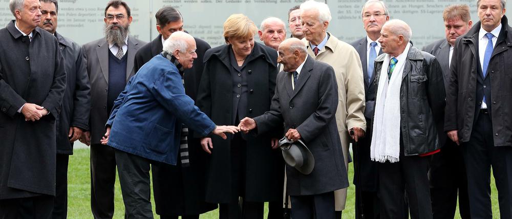 Tag der Einweihung: In Gegenwart der Kanzlerin reichen sich Dani Karavan (links) und ein Überlebender des NS-Völkermords an den Sinti und Roma vor dem neuen Mahnmal die Hände. 