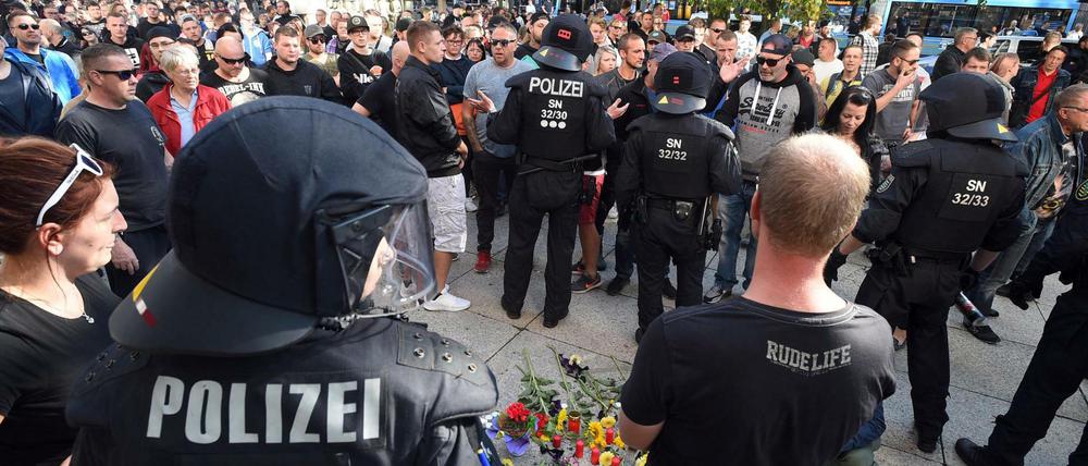 Polizisten und Bürger in Chemnitz an der Stelle, wo ein Mann erstochen wurde.