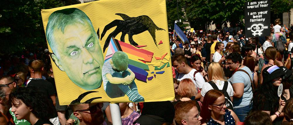 Menschen halten bei einer Gay Pride Parade in Budapest ein Plakat mit dem Gesicht des ungarischen Ministerpräsidenten Orban.