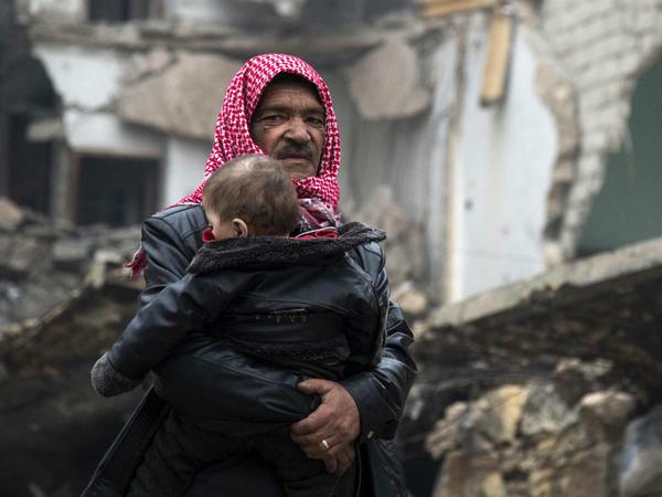 Ein Mann mit einem Kind in Aleppo auf der Suche nach Zuflucht.