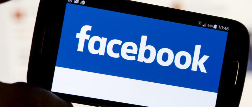 Der Schriftzug der Social Media-Plattform Facebook ist auf einem Handy zu sehen.