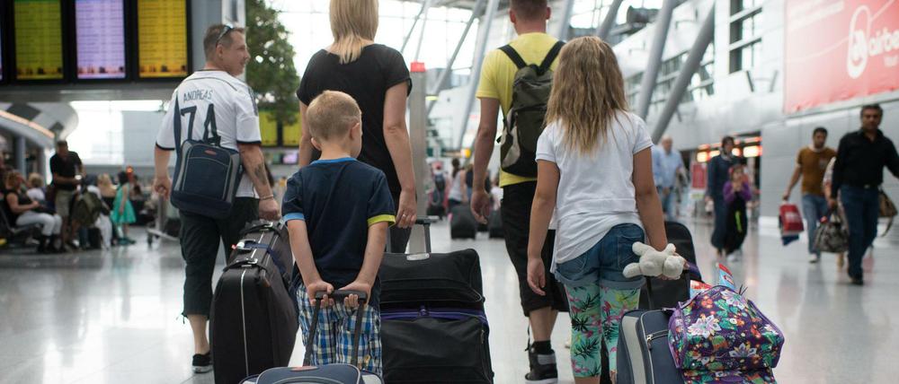 Eine Familie läuft auf dem Flughafen in Düsseldorf zum Check-In für ihren Flug. (Symbolbild)