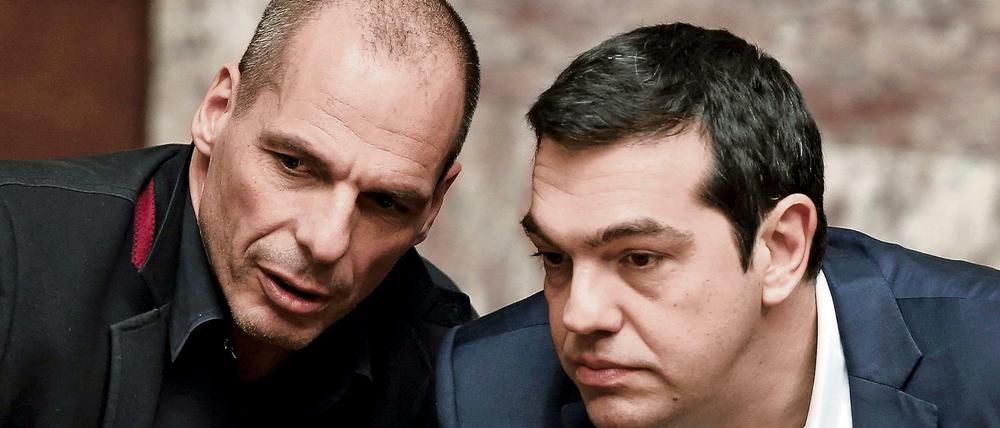Greek Prime Minister Alexis Tsipras (R) and Finance Minister Yanis Varoufakis talk during the first round of a presidential vote at the Greek parliament in Athens, Greece in this February 18, 2015 file photo. To match Special Report EUROZONE-GREECE/TSIPRAS REUTERS/Alkis Konstantinidis/Files