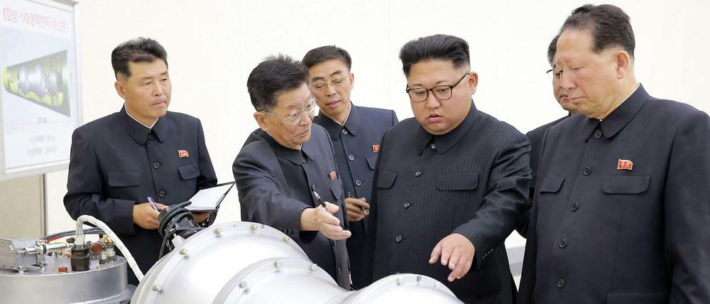 Nordkoreas Diktator Kim Jong Un besichtigt einen nuklearen Sprengkopf.