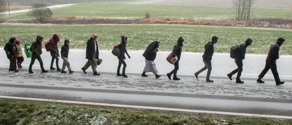 Flüchtlinge gehen an der deutsch-österreichischen Grenze während eines Schneeschauers nach Deutschland. 