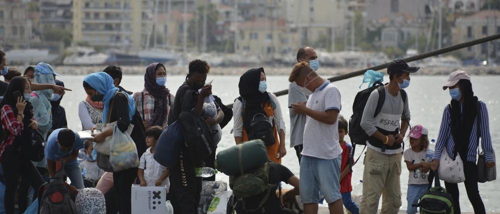 Migranten stehen Schlange, um eine Fähre von der Insel Lesbos zum griechischen Festland zu besteigen. 