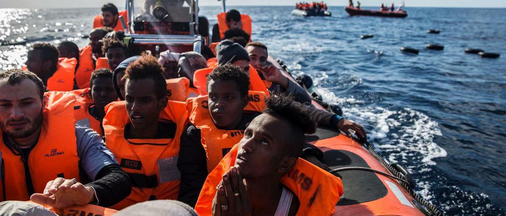 Migranten sitzen in einem Schlauchboot, nachdem eine NGO aus Spanien sie im Mittelmeer gerettet hat.