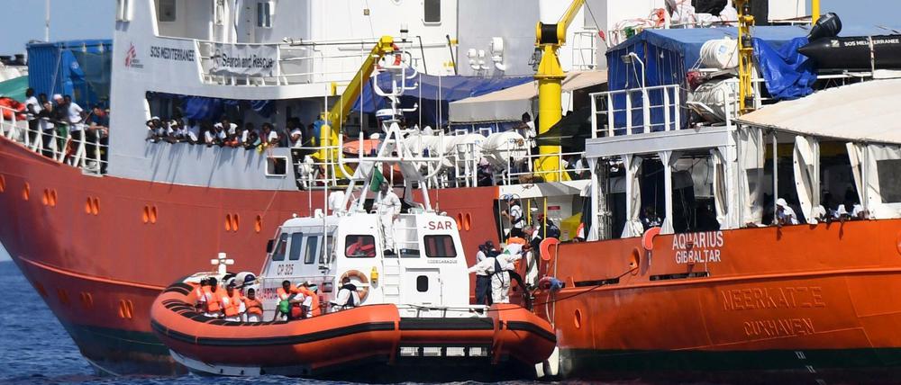 Ein Schiff der italienischen Küstenwache legt am Rettungsschiff Aquarius an.