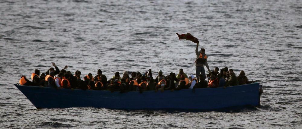 Flüchtlinge aus Afrika rufen auf dem Mittelmeer in einem Boot um Hilfe (Archivbild).