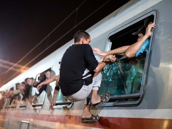 Ein Flüchtling klettert am Freitag durch ein Fenster in einen überfüllten Waggon eines Zuges am Bahnhof des Dorfes Tovarnik in Kroatien, zum weiteren Transit in andere EU-Staaten. Kroatien ist vom Ansturm der Menschen überrascht worden. 