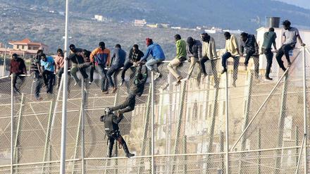 Flüchtlinge versuchen, den Grenzzaun der spanischen Exklave Melilla zu überwinden.