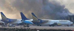 Flammen und Rauch steigen aus einem Gebäude des Flughafens von Karachi auf.