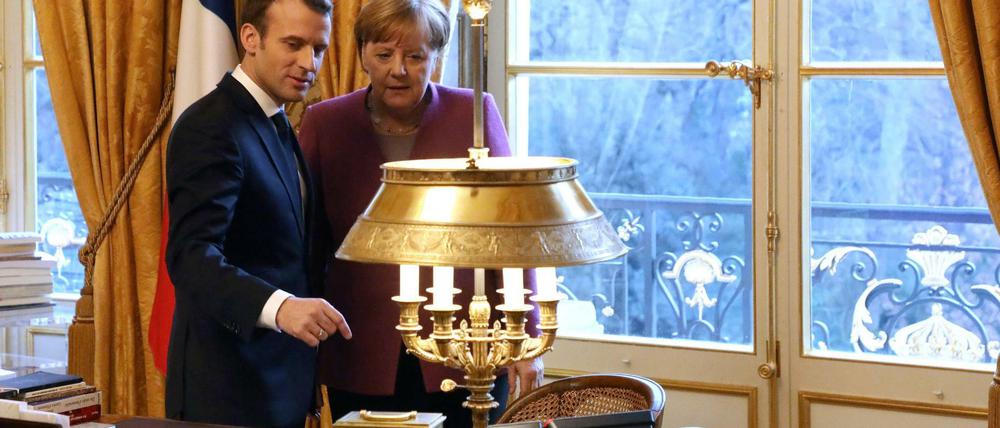 Lesen für Europa im Korbstuhl. Angela Merkel im Amtssitz von Emmanuel Macron.