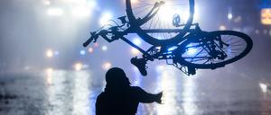 Ein Randalierer wirft in Hamburg im Schanzenviertel ein Fahrrad in Richtung von Wasserwerfern. 