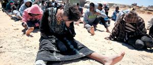 Zurück in der Hölle: Eine Gruppe von Geflüchteten, die die libysche Küstenwache im Meer aufgriff, nach der Landung an einem Strand bei Tripolis