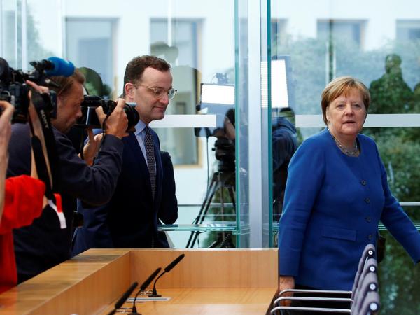 Merkel und Gesundheitsminister Jens Spahn versuche den Eindruck zu zerstreuen, sie würden nicht gut zusammenarbeiten. 