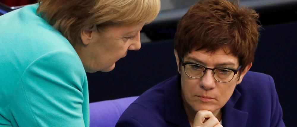 Angela Merkel (links) spricht im Bundestag mit Annegret Kramp-Karrenbauer.