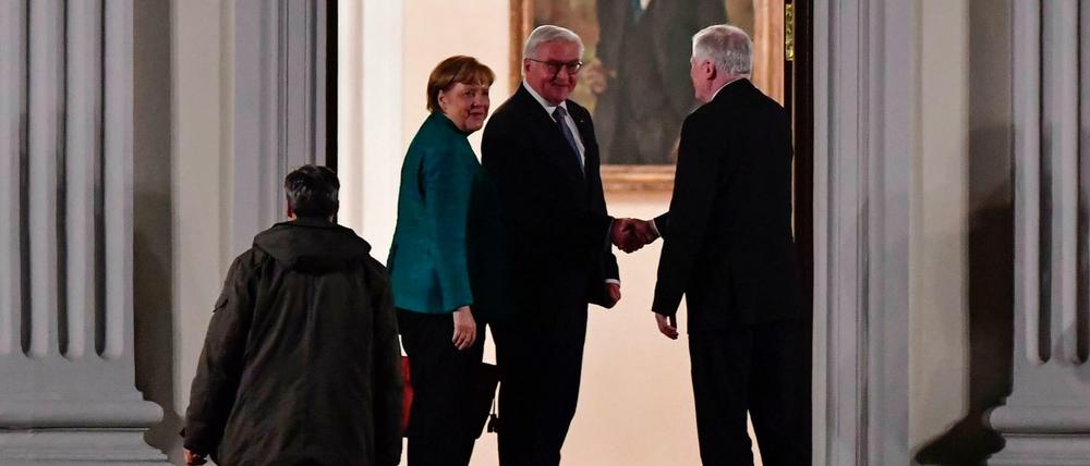 Bundespräsident Frank-Walter Steinmeier begrüßt am Donnerstagabend am Eingang von Schloss Bellewue Angela Merkel und Horst Seehofer. 