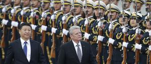 Bundespräsident Joachim Gauck and Chinas Präsident Xi Jinping schreiten vor der Großen Halle des Volkes in China die Ehrengarde ab. 