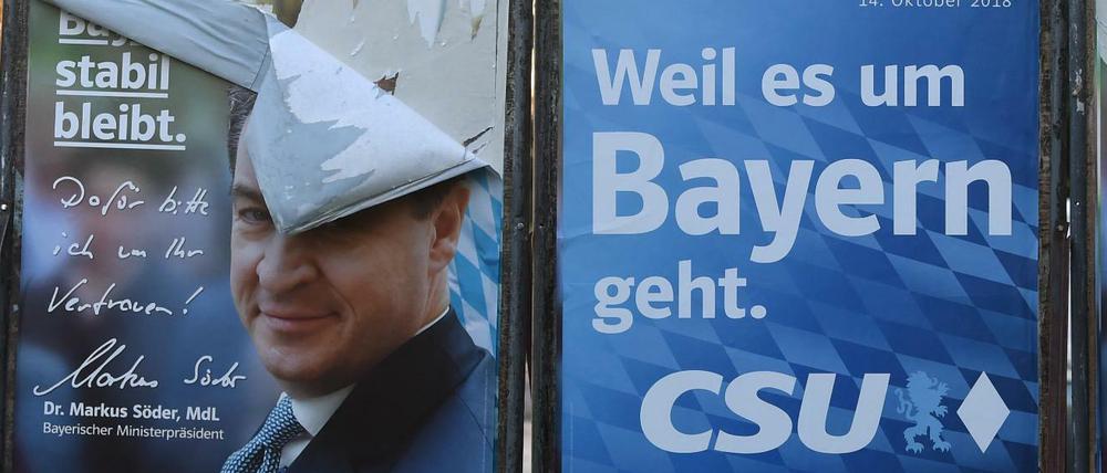 Der bayerische Ministerpräsident Markus Söder (CSU) auf einem zerstörten Wahlplakat in München. 