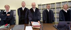 Der Vorsitzende Richter Manfred Götzl (Mitt) und sein Staatsschutzsenat stehen am 22.07.2014 im Gerichtssaal in München (Bayern) hinter der Richterbank.