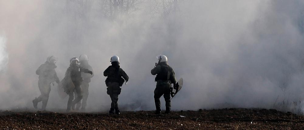 Griechische Bereitschaftspolizisten stehen inmitten von Tränengaswolken in der Nähe des türkischen Grenzübergangs.