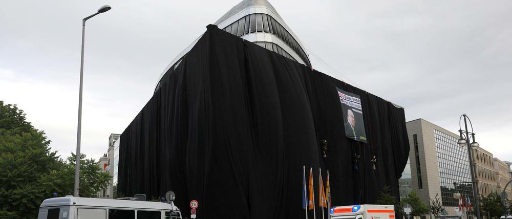 Greenpeace-Aktivisten haben die CDU-Zentrale in Berlin mit schwarzem Stoff bedeckt.