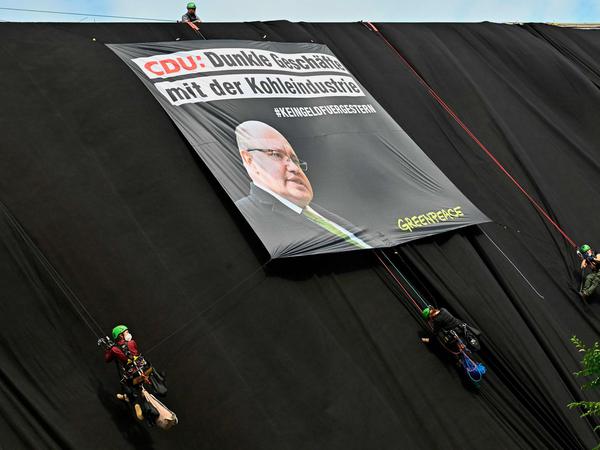 Die Aktivisten haben am Konrad-Adenauer-Haus ein Plakat mit dem Bild von Bundeswirtschaftsminister Peter Altmaier aufgespannt. 