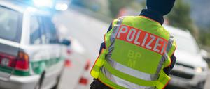 Ein Polizeibeamter beobachtet an der Anschlussstelle Bad Reichenhall der Autobahn A8 von Salzburg nach München Fahrzeuge, die aus Österreich kommen. 